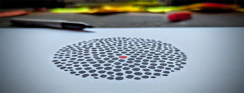 Image of black and red dots in a circle on paper
