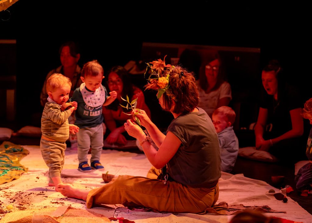 Babies engaging with the performer in the round of a theatre space